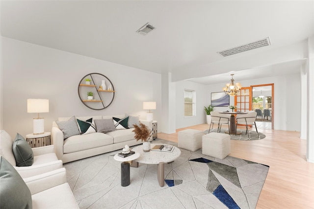 living room with light wood-type flooring and a chandelier