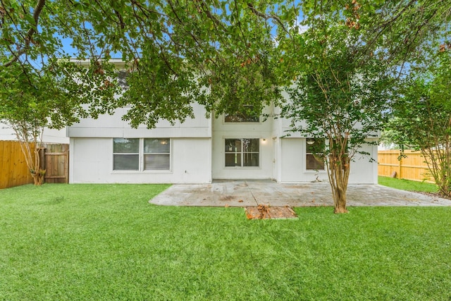 rear view of property featuring a lawn and a patio