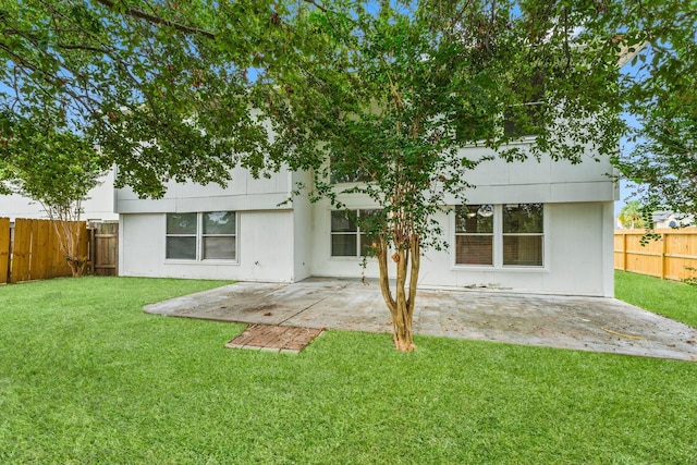 back of house featuring a lawn and a patio