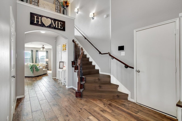 foyer entrance featuring a high ceiling, wood-type flooring, and ceiling fan