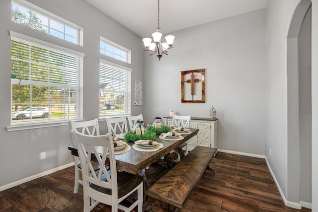 dining space featuring dark wood-type flooring and a chandelier