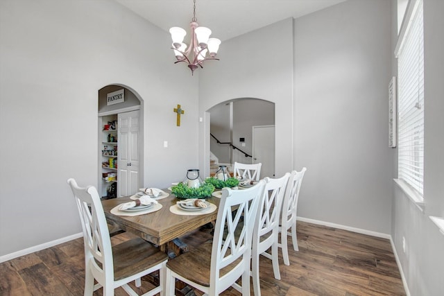 dining area with a notable chandelier and dark hardwood / wood-style flooring