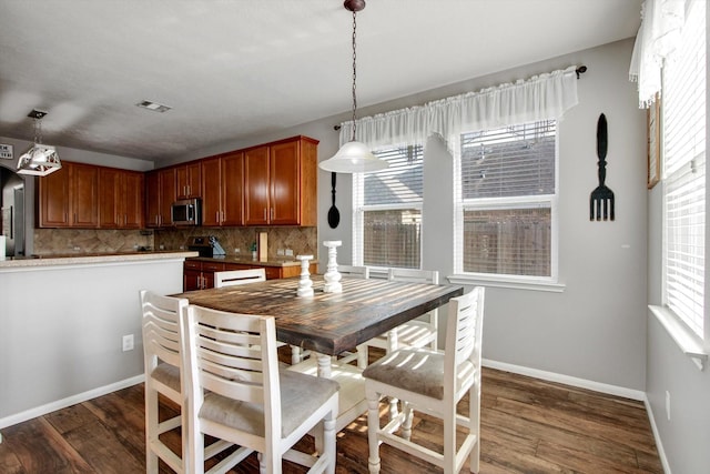 dining area featuring dark wood-type flooring