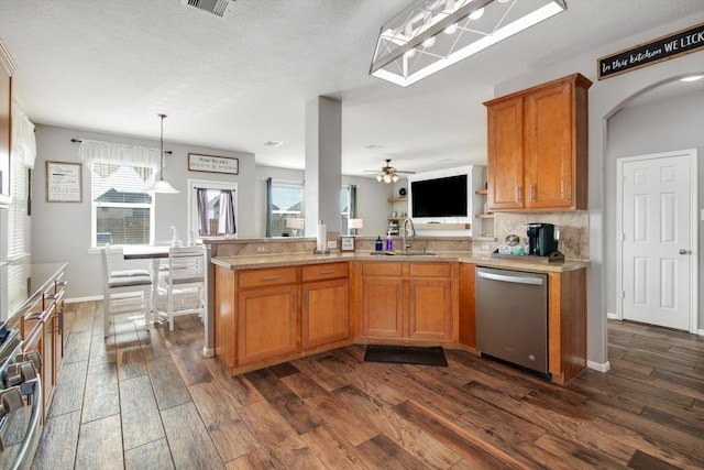 kitchen featuring sink, decorative light fixtures, dark hardwood / wood-style floors, dishwasher, and backsplash