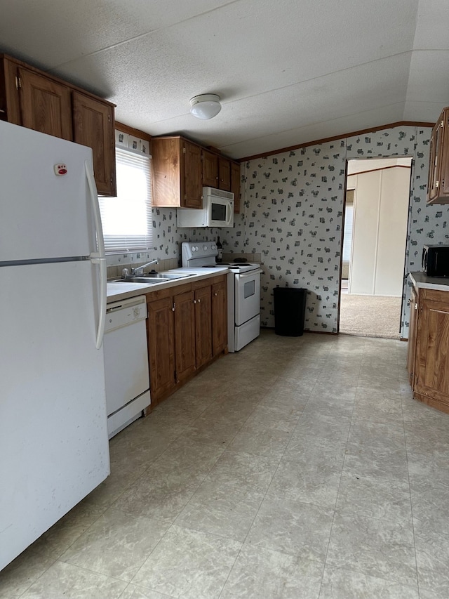 kitchen with lofted ceiling, sink, and white appliances