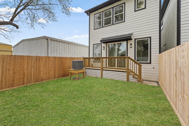 back of house featuring a wooden deck, central AC unit, and a lawn