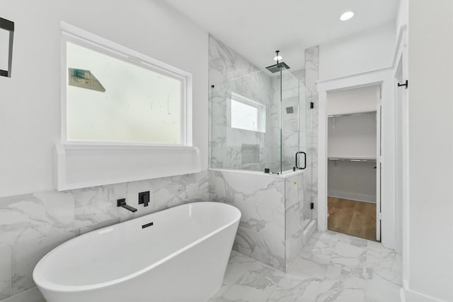 bathroom featuring separate shower and tub and tile walls