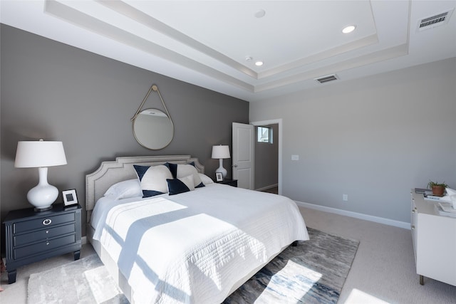 carpeted bedroom with a tray ceiling