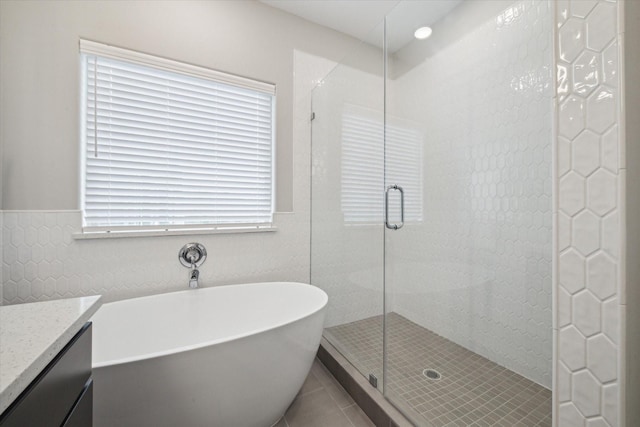 bathroom featuring vanity, plus walk in shower, and tile patterned flooring