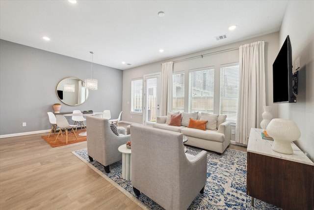 living room featuring an inviting chandelier and light hardwood / wood-style floors