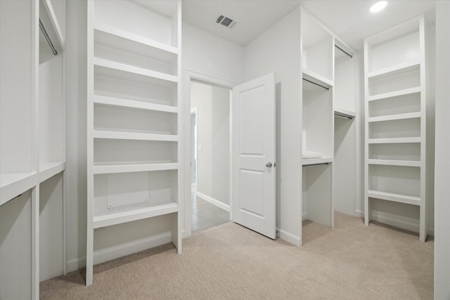 walk in closet featuring light colored carpet