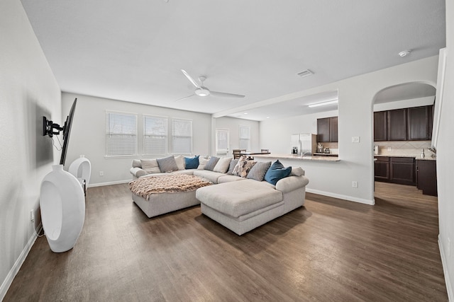 living room featuring ceiling fan and dark hardwood / wood-style floors