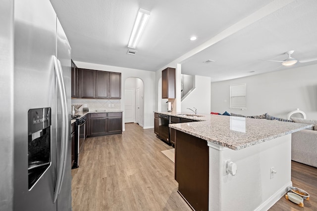 kitchen with dark brown cabinetry, tasteful backsplash, appliances with stainless steel finishes, and light hardwood / wood-style floors