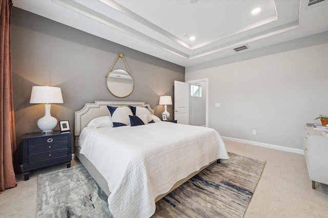 carpeted bedroom featuring a raised ceiling