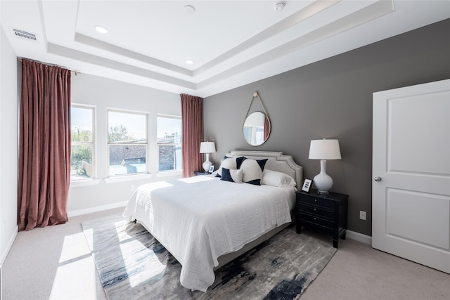 carpeted bedroom with a tray ceiling