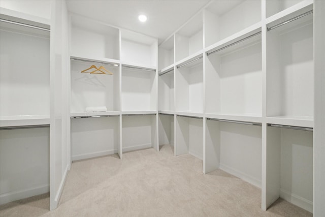 walk in closet with light colored carpet