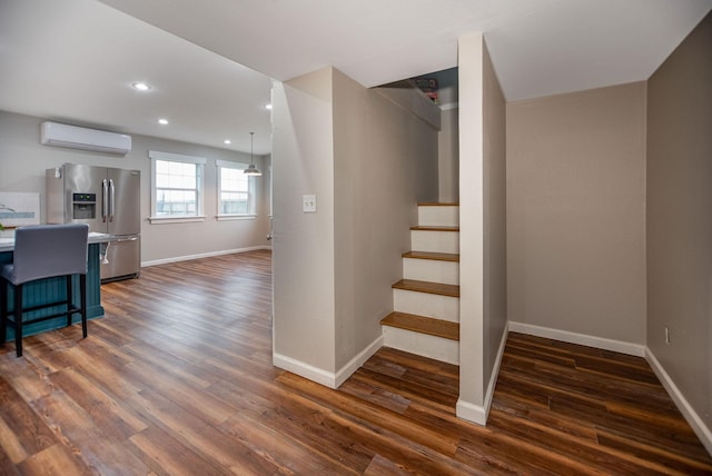 stairs featuring hardwood / wood-style flooring and a wall mounted AC