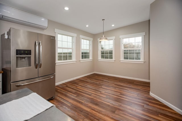 kitchen featuring a wall mounted air conditioner, stainless steel fridge, dark hardwood / wood-style flooring, and decorative light fixtures