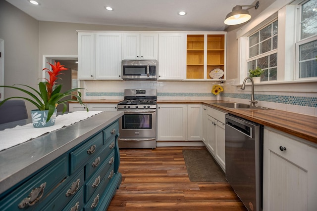 kitchen with sink, white cabinets, stainless steel appliances, dark wood-type flooring, and blue cabinetry