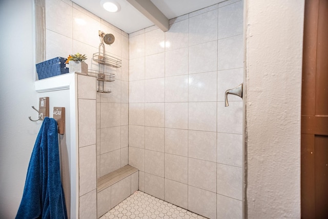 bathroom with beamed ceiling and a tile shower