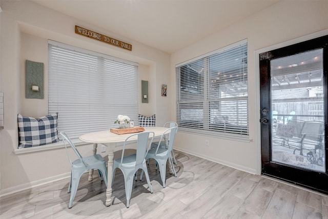 dining room with light wood-type flooring and baseboards