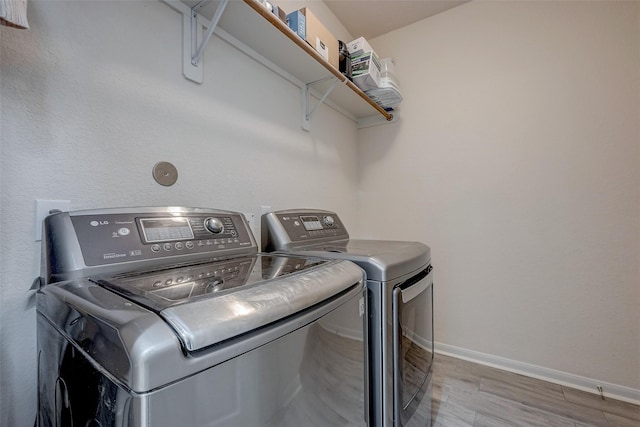 clothes washing area featuring separate washer and dryer and light wood-type flooring