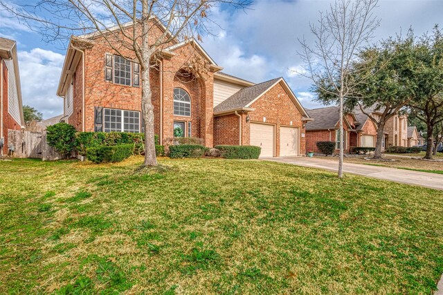 traditional-style house featuring a front yard, brick siding, concrete driveway, and an attached garage