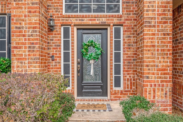 doorway to property with brick siding