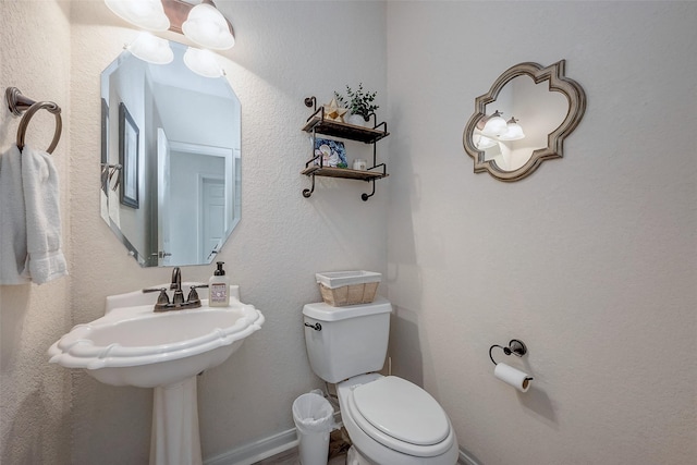 half bathroom featuring toilet and baseboards