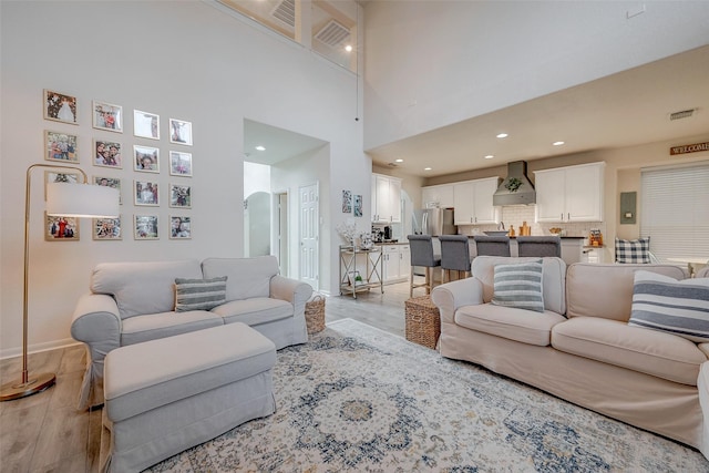 living room featuring a high ceiling and light wood-type flooring