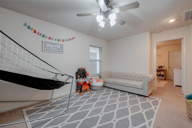 carpeted living area featuring visible vents and ceiling fan