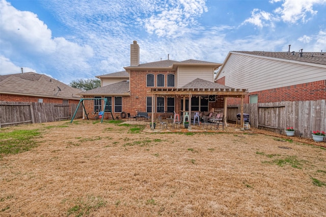 rear view of property with a yard, a patio area, and a playground