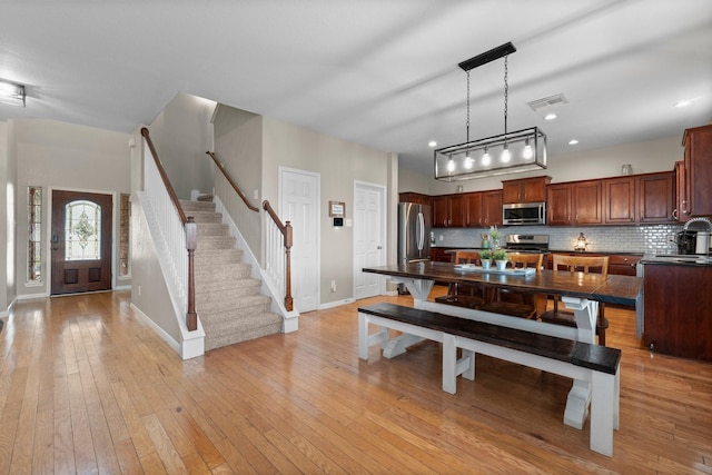 dining area with baseboards, visible vents, stairs, light wood-style floors, and recessed lighting