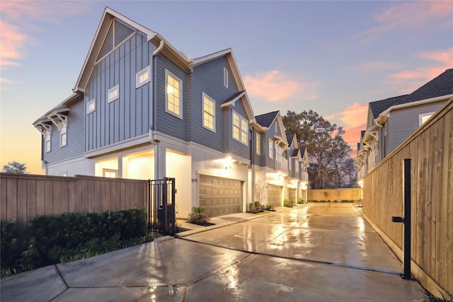 6024 T C Jester Blvd, Houston, TX 77091 - property exterior at dusk featuring board and batten siding, an attached garage, fence, and concrete driveway