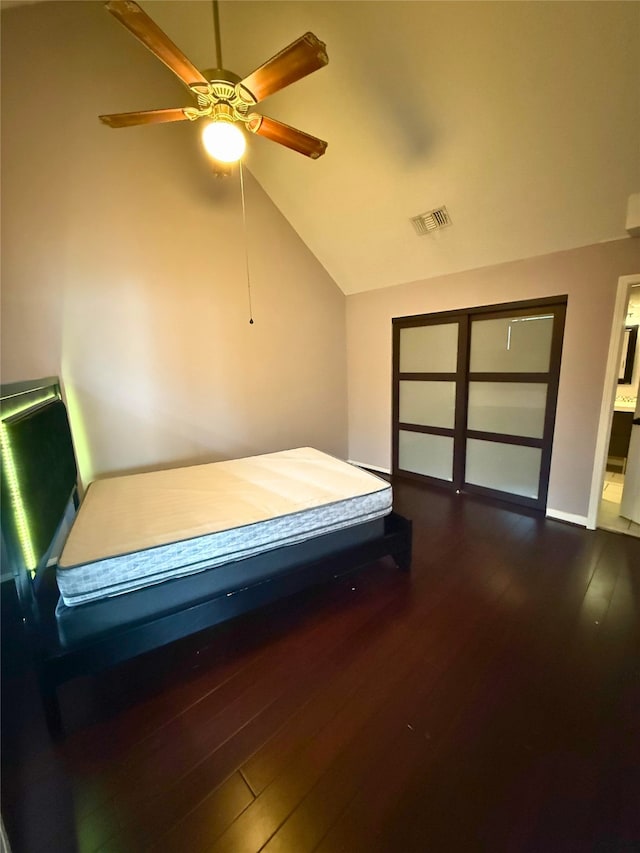 bedroom with ceiling fan, lofted ceiling, and dark hardwood / wood-style flooring