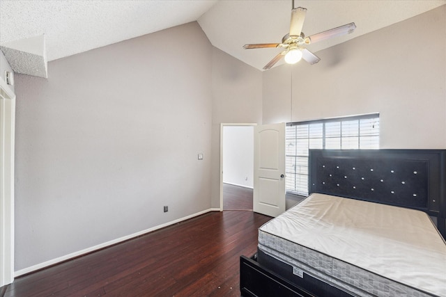 bedroom featuring ceiling fan, dark hardwood / wood-style floors, and high vaulted ceiling