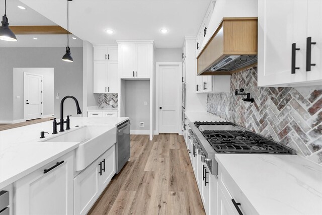 kitchen with white cabinetry, stainless steel dishwasher, sink, and hanging light fixtures