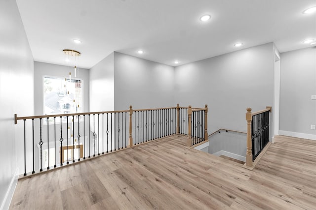 hallway with a chandelier and light hardwood / wood-style floors