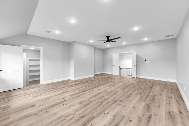 unfurnished living room with ceiling fan, vaulted ceiling, and light hardwood / wood-style floors