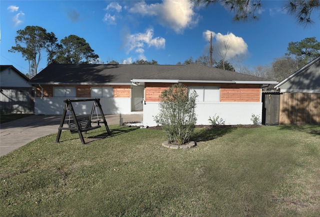 single story home featuring roof with shingles, a front yard, and fence