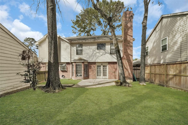 back of property with a patio, a yard, and french doors