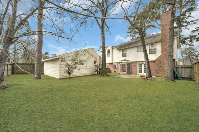 back of property with a lawn and a patio area