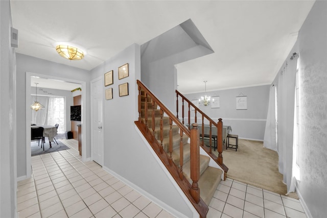 stairway featuring an inviting chandelier, ornamental molding, and tile patterned flooring