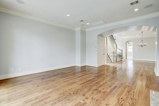 unfurnished room with ornamental molding, a notable chandelier, and light hardwood / wood-style floors