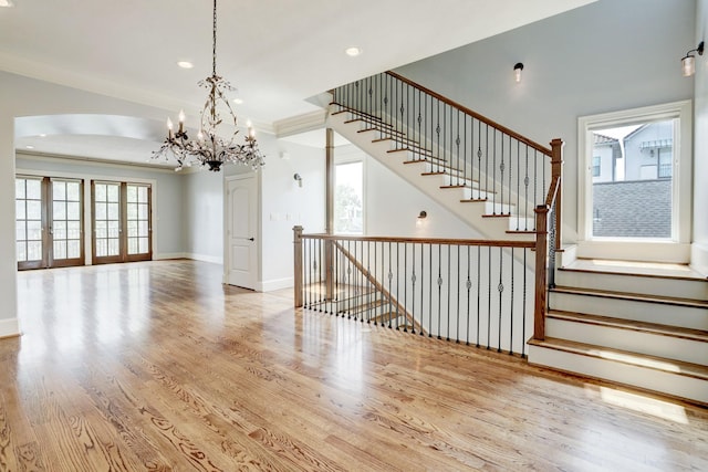 interior space featuring french doors, ornamental molding, and light hardwood / wood-style flooring