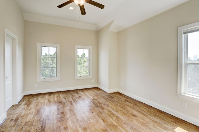 empty room with ceiling fan, a healthy amount of sunlight, and light hardwood / wood-style floors