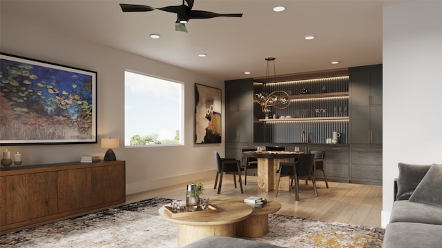 interior space featuring ceiling fan with notable chandelier and light wood-type flooring