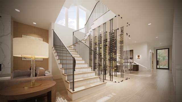 staircase with a towering ceiling and hardwood / wood-style floors