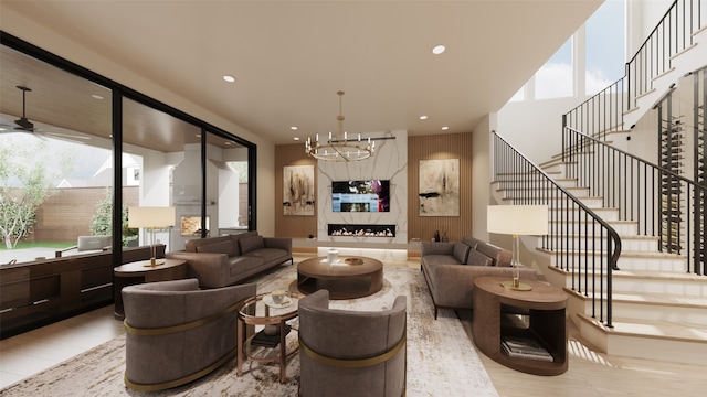 living room featuring ceiling fan with notable chandelier and a fireplace