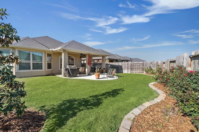 back of house with a lawn and a patio